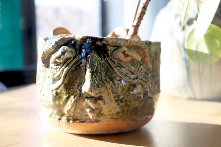 Unikalna doniczka z wyrzeźbioną głową to praktyczny pojemnik na kwiatki, ręcznie robiony z wysokiej jakości ceramiki, w butelkowej zieleni